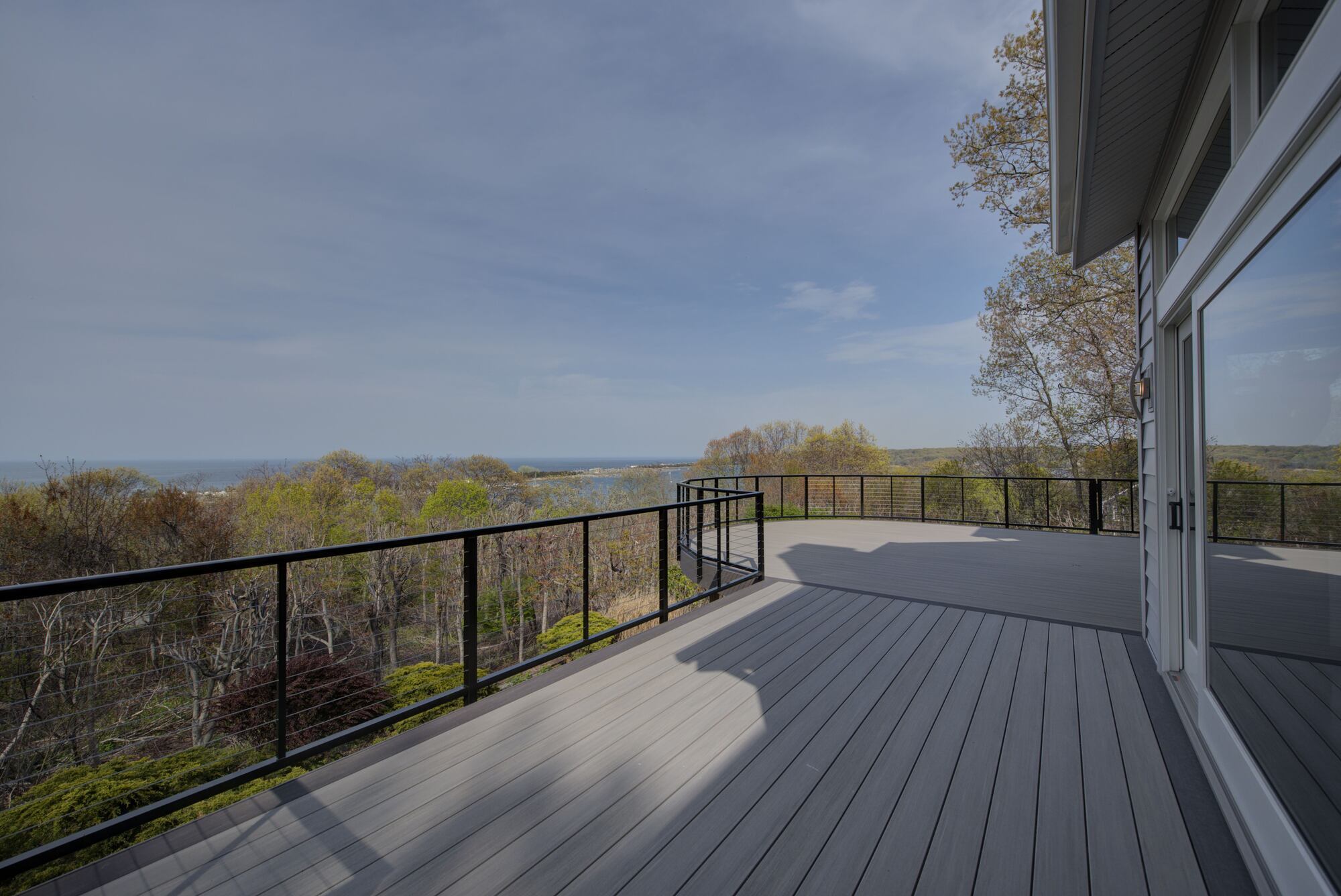 Wide-angle view of a composite deck and surrounding nature in a Northport, NY custom home project