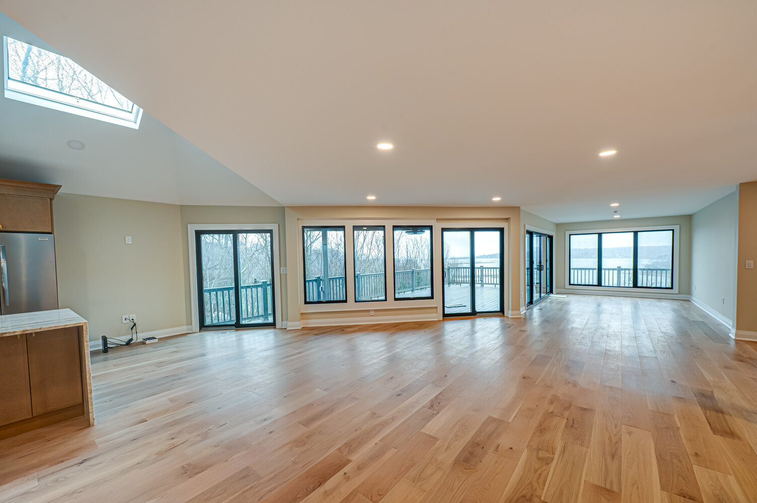 Expansive living room with sliding doors and wood floors in a custom home by Long Island Creative Contracting in Miller Place, NY