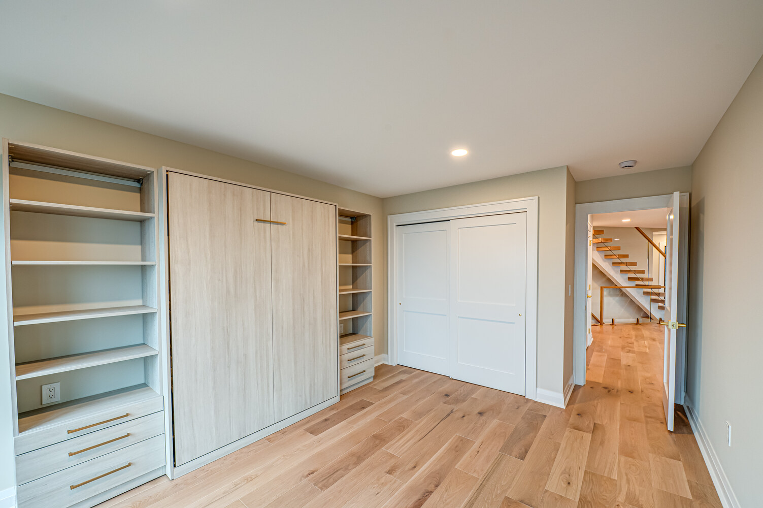 Functional bedroom with integrated storage and hardwood floors in Miller Place by Long Island Creative Contracting