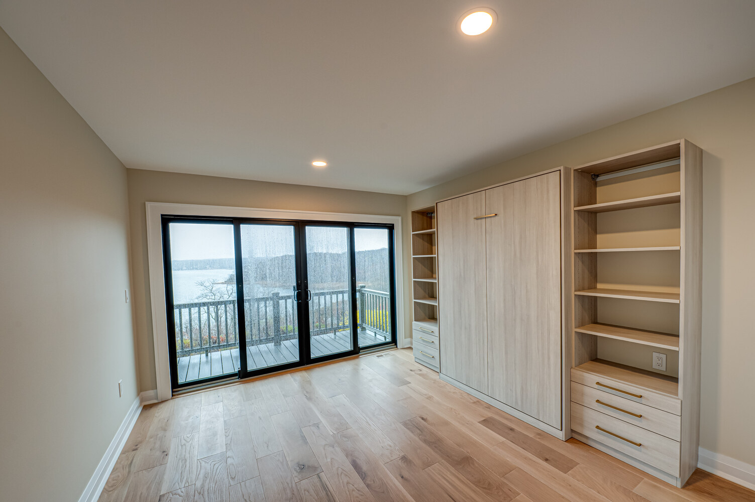 Lake-view bedroom with built-in shelving in a custom home build by Long Island Creative Contracting in Miller Place, NY