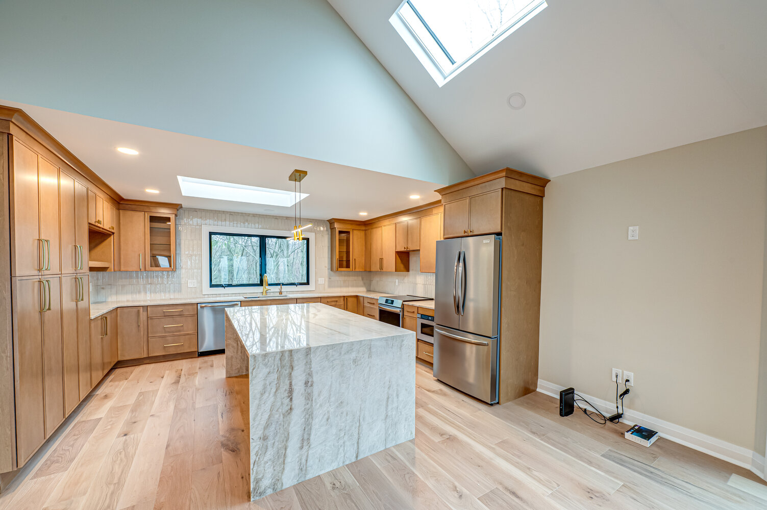 Modern kitchen remodel with skylights and large center island in a Miller Place custom home by Long Island Creative Contracting
