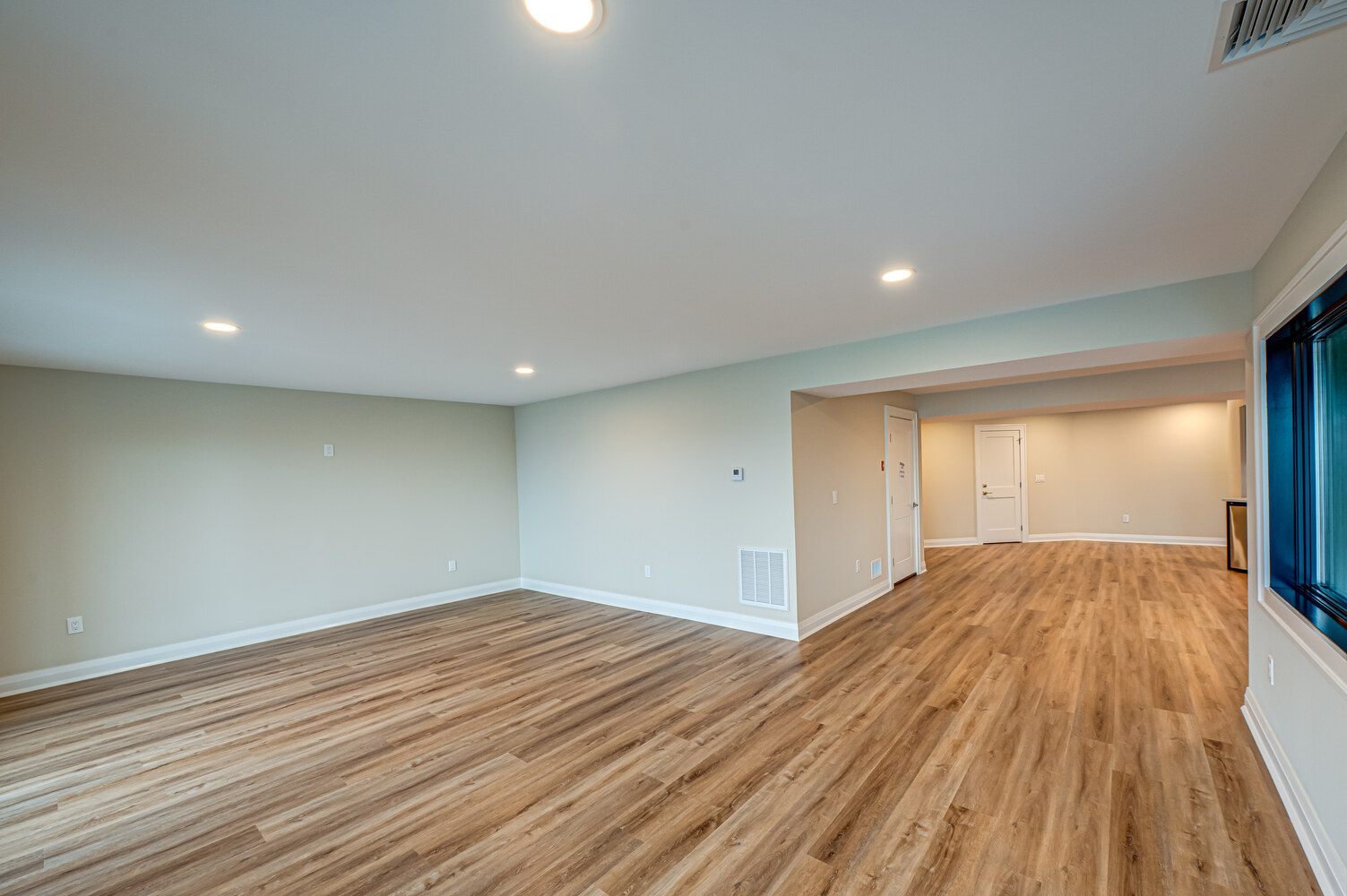 Open basement area with luxury vinyl flooring in a Miller Place custom home by Long Island Creative Contracting