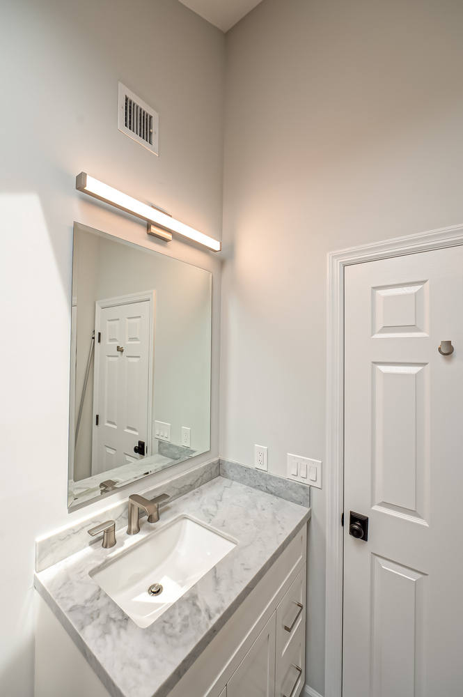 Compact bathroom vanity with marble countertop in custom Long Island home by Long Island Creative Contracting