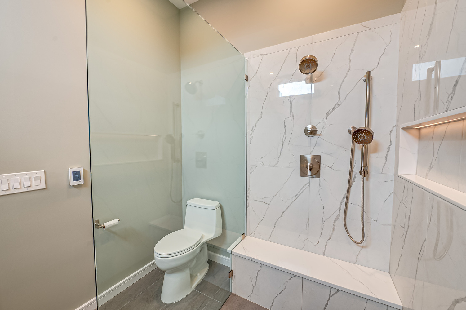 Contemporary shower and toilet design with frosted glass divider in Stony Brook, NY custom home