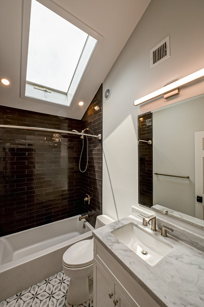 Custom bathroom featuring large tiled shower and modern sink setup in Northport, NY