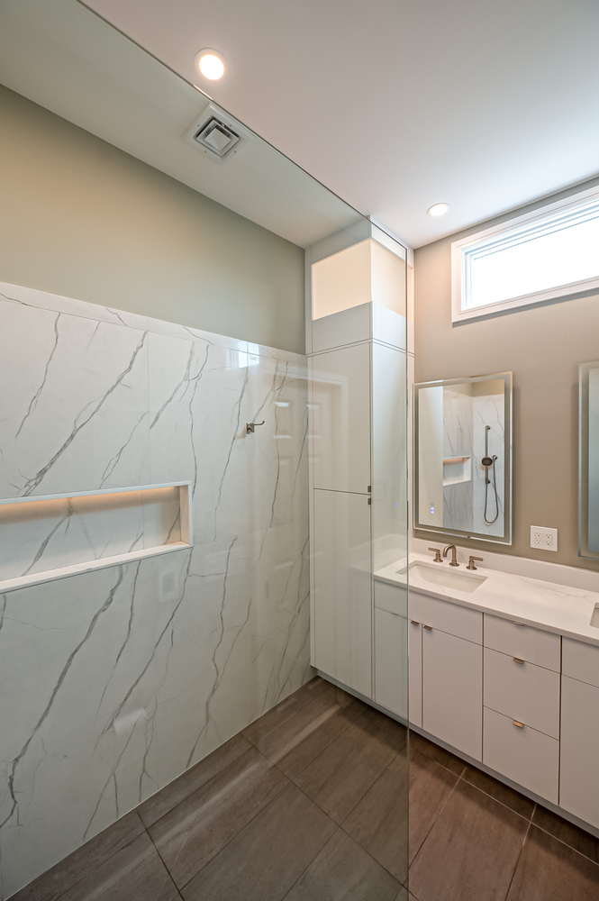 Spacious bathroom layout with large vanity and tiled walls by Long Island Creative Contracting in Setauket, NY