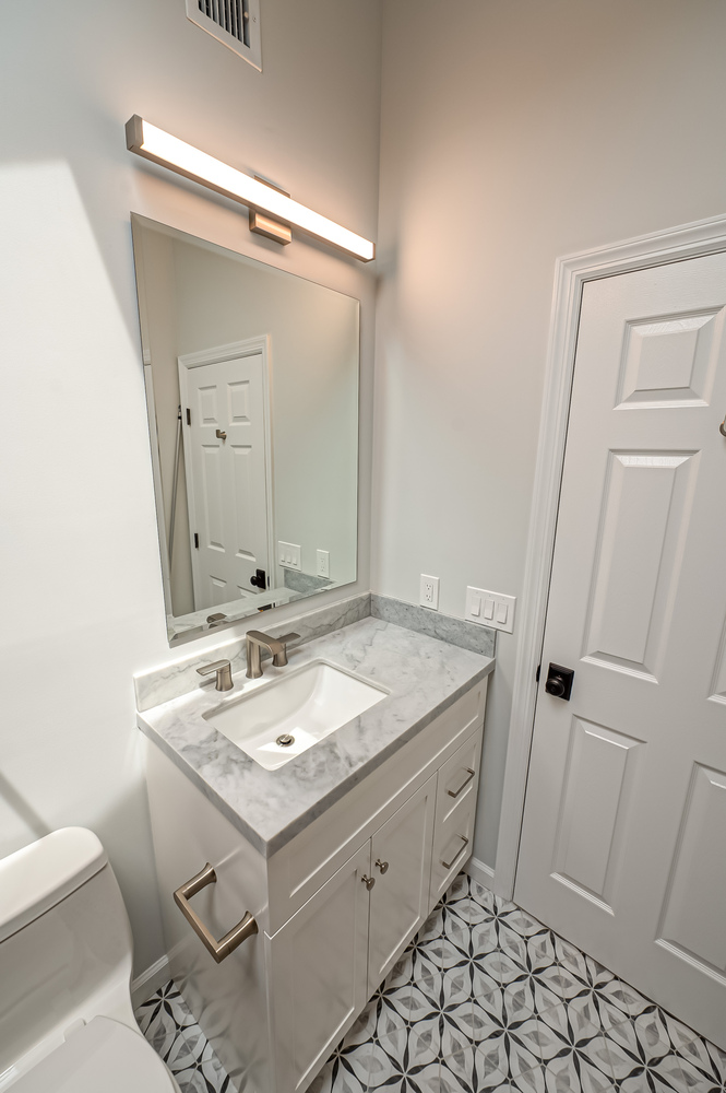 Stylish small bathroom design with LED vanity lighting in Northport home by Long Island Creative Contracting