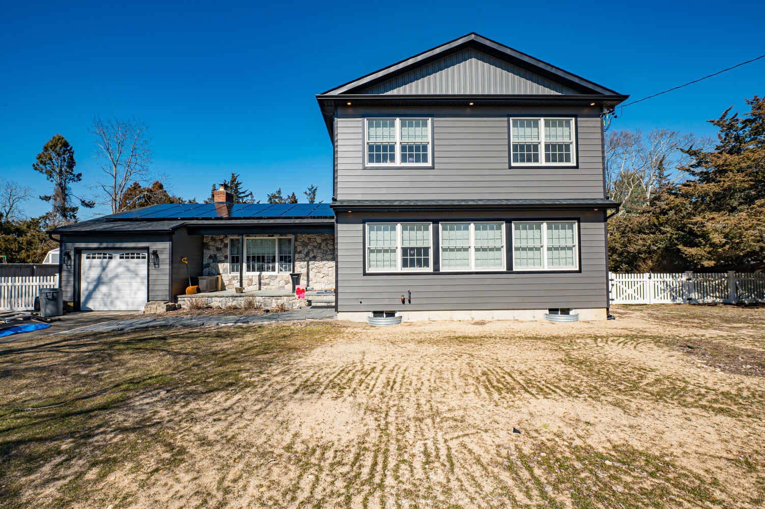 Exterior view of two-story custom home with gray siding by Long Island Creative Contracting, Inc. in Miller Place, NY