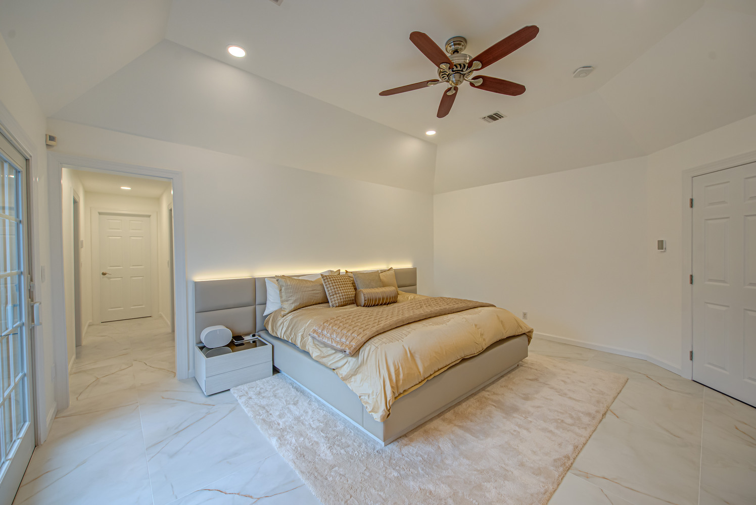 Custom bedroom with gold bedding and built-in lighting in Miller Place, NY by Long Island Creative Contracting, Inc