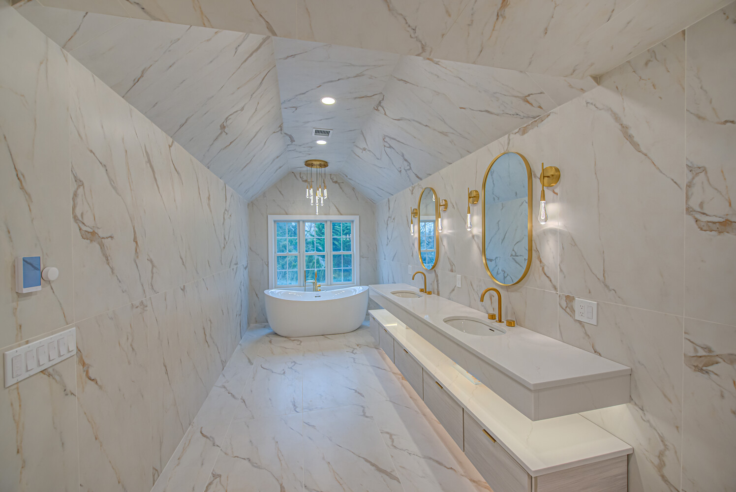 Elegant custom-built bathroom featuring dual vanities and chandelier lighting in Miller Place, NY by Long Island Creative Contracting, Inc