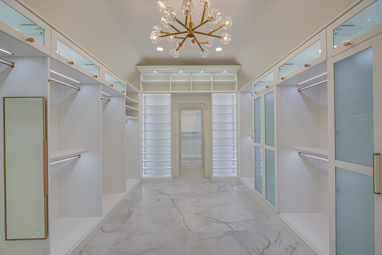 Luxury closet with frosted glass cabinets and center aisle design by Long Island Creative Contracting, Inc. in Huntington, NY
