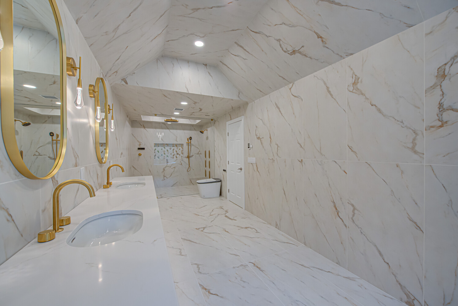 Open shower and floating vanity in luxurious marble bathroom built by Long Island Creative Contracting, Inc. in Woodbury, NY