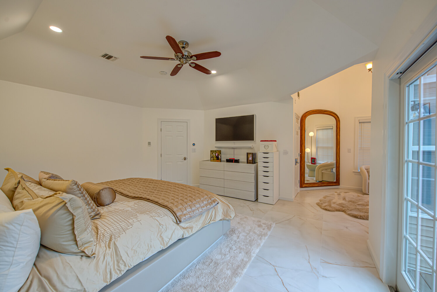 Warmly lit bedroom with decorative ceiling fan and luxurious furniture in Miller Place, NY by Long Island Creative Contracting, Inc