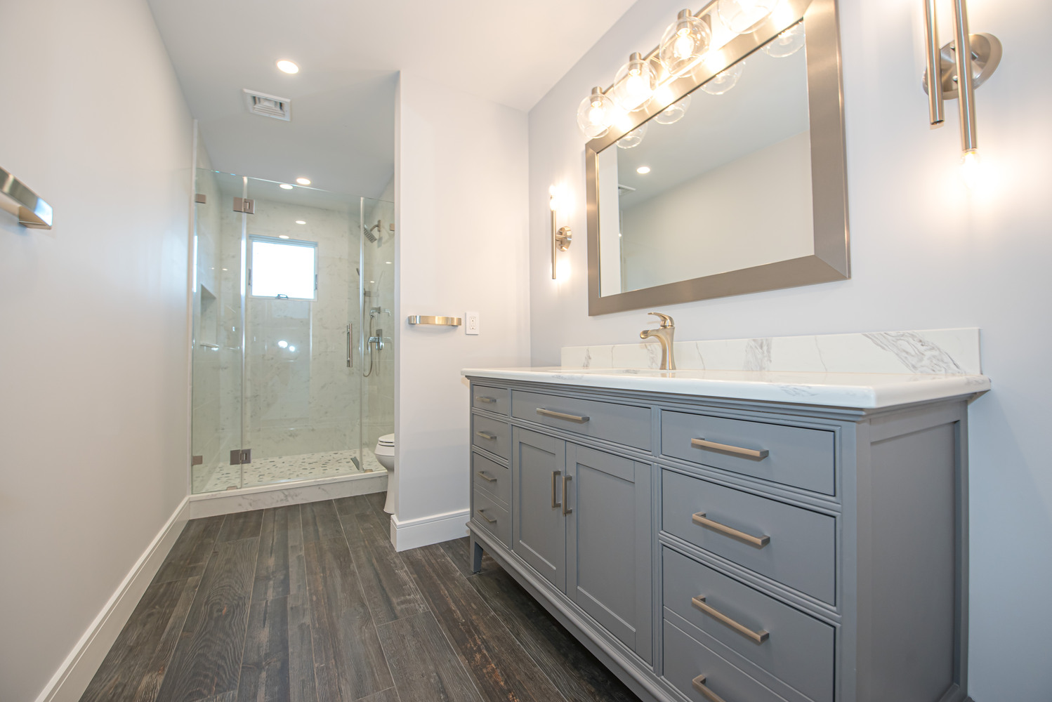 Custom bathroom remodel with dual-sink vanity and frameless glass shower in East Setauket, NY by Long Island Creative Contracting, Inc