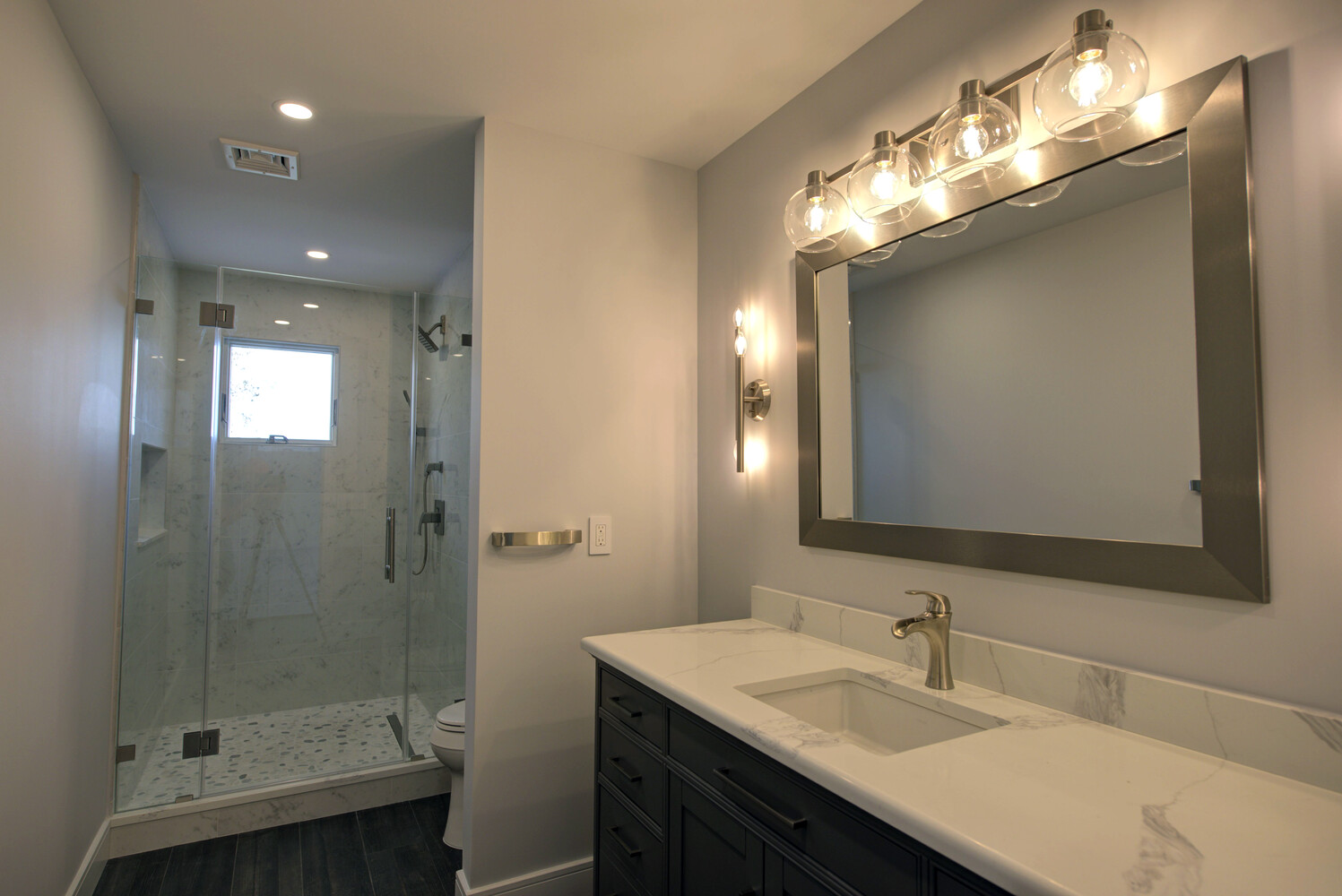 Custom bathroom vanity and tiled walk-in shower in a Port Jefferson Station, NY home by Long Island Creative Contracting, Inc