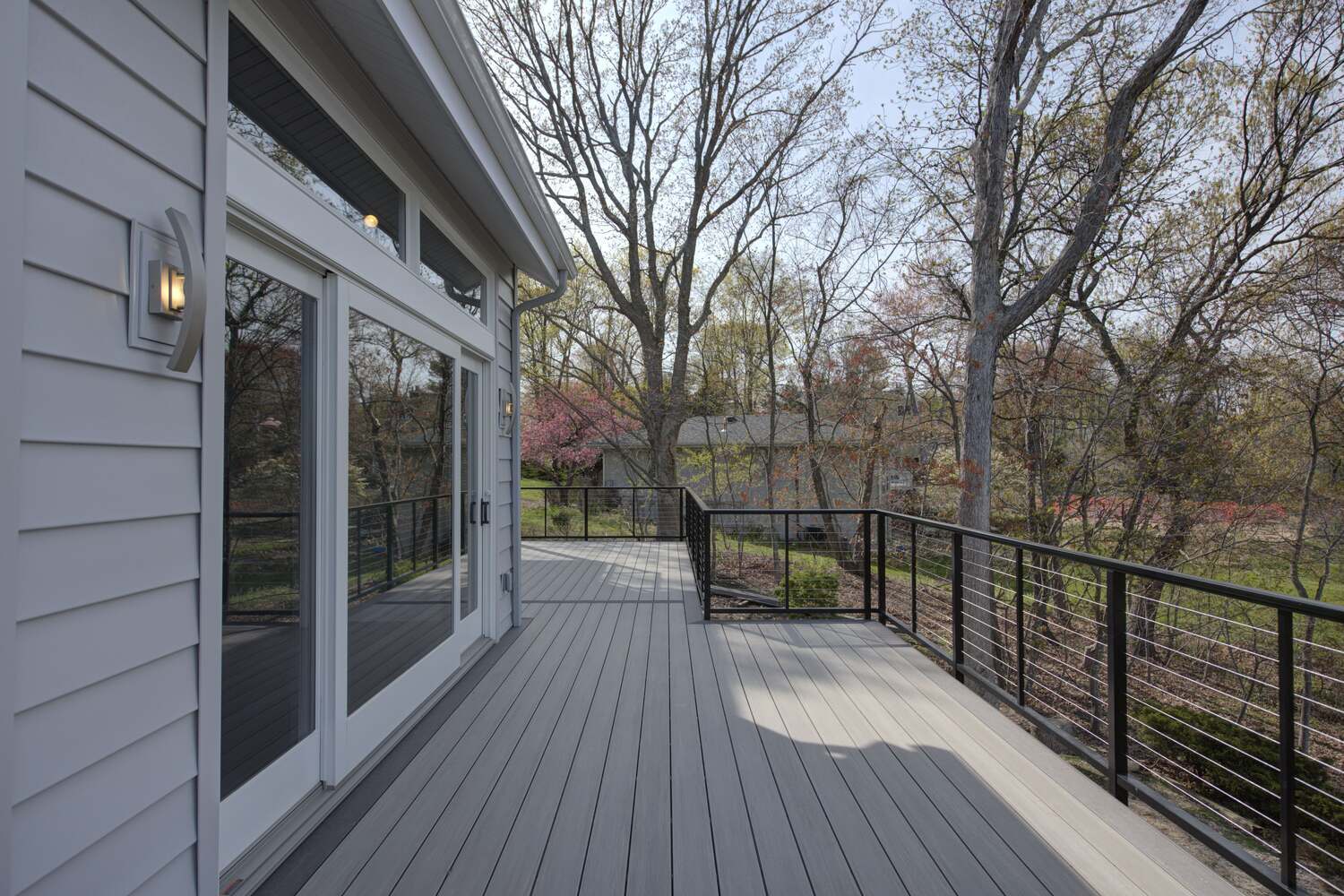 Custom home deck with spring trees and black cable railings in Poquott, NY by Long Island Creative Contracting, Inc Custom home deck with spring trees and black cable railings in Poquott, NY by Long Island Creative Contracting, Inc