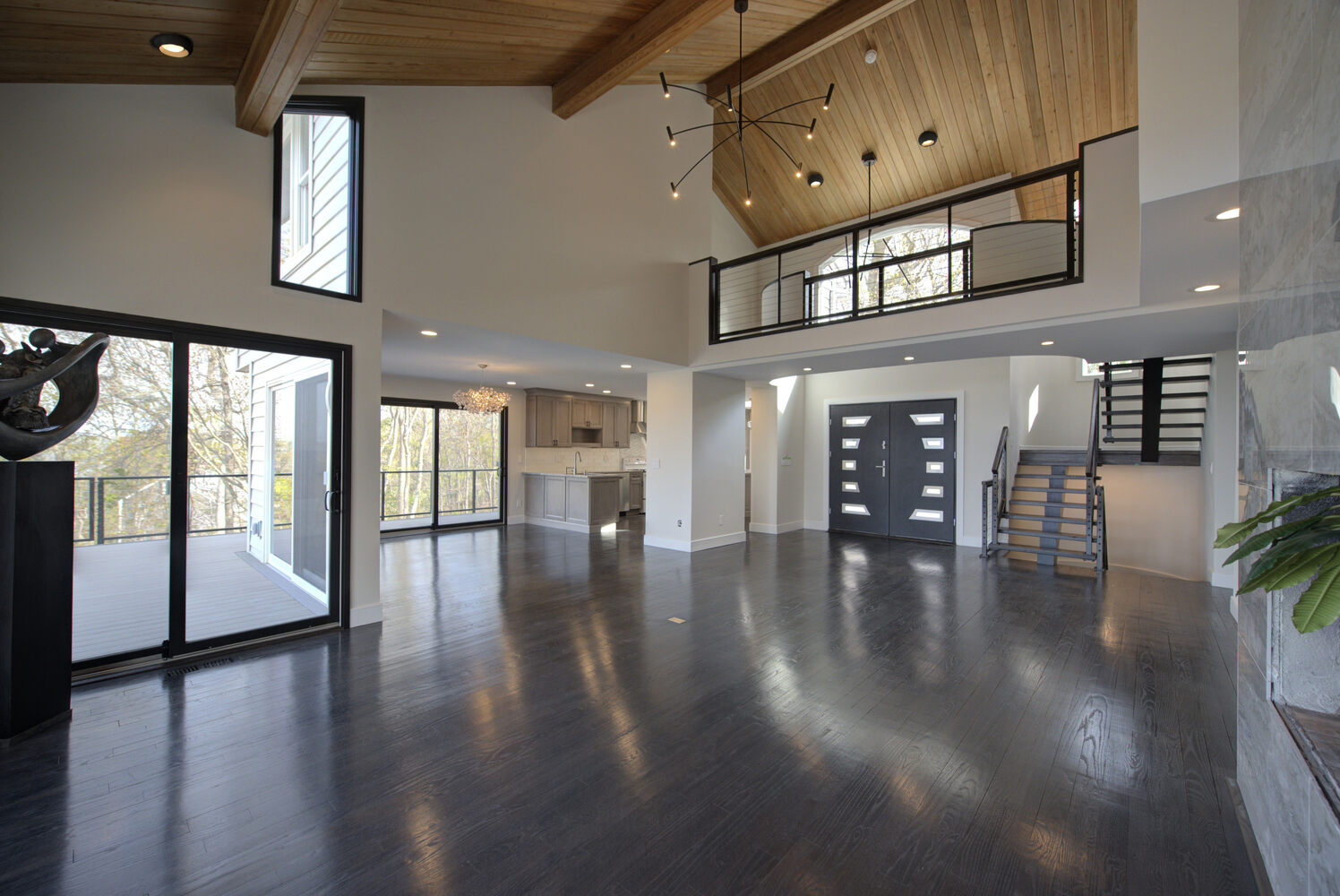 Expansive living space with double doors and open balcony in a custom home by Long Island Creative Contracting, Inc., Northport, NY