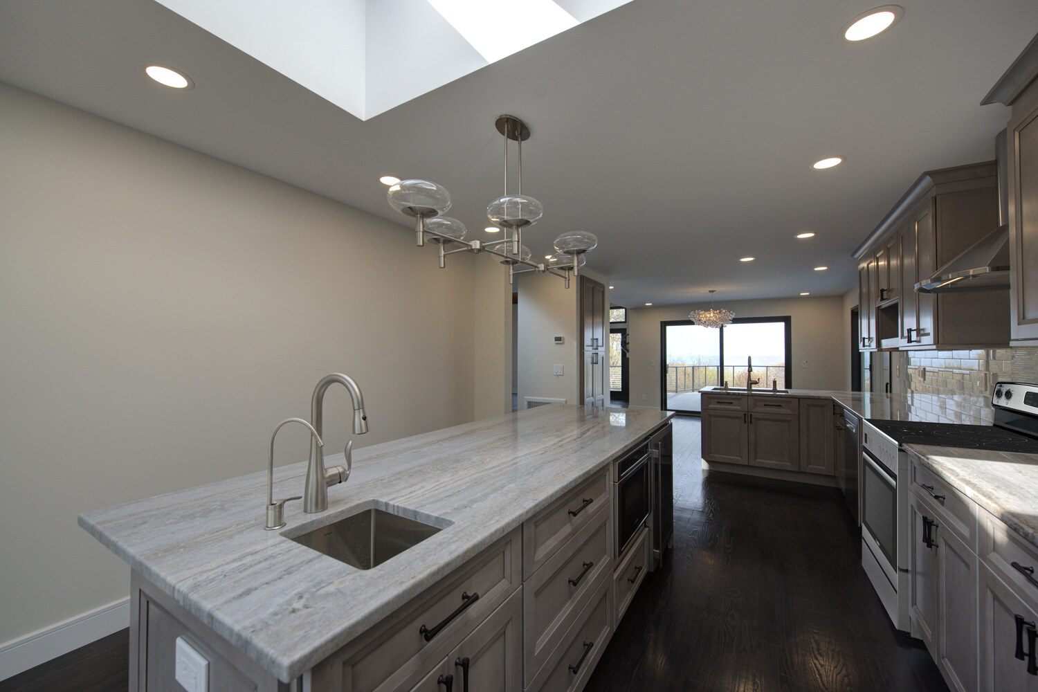 Luxury kitchen island with pendant lighting in a custom home by Long Island Creative Contracting, Inc. in Woodbury, NY