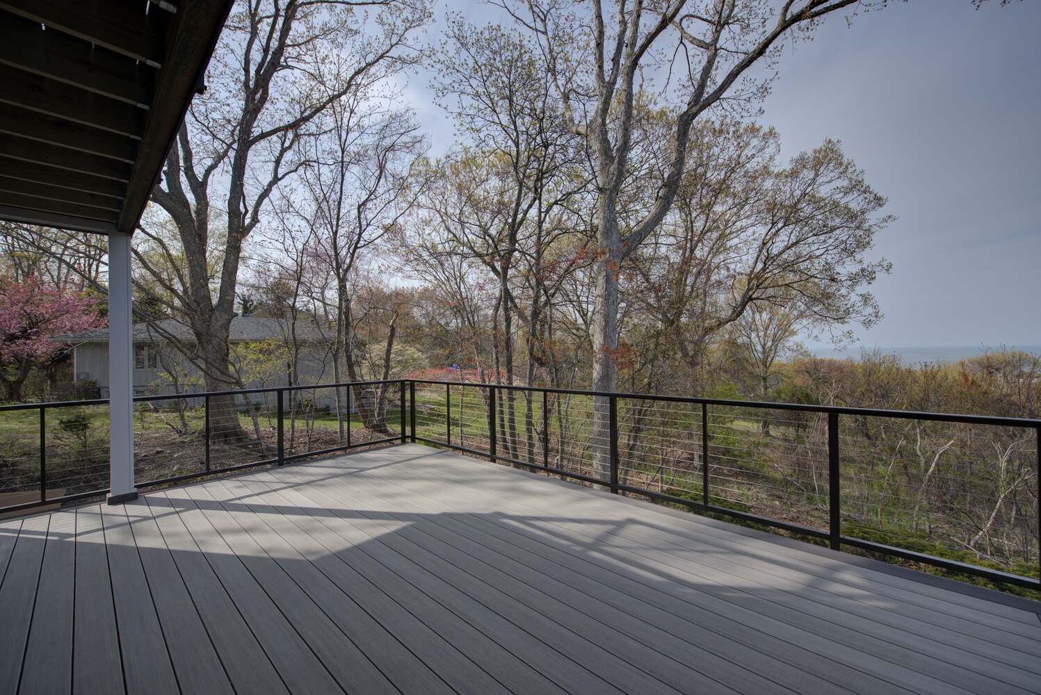 Peaceful outdoor retreat with treetop and water views in a custom Long Island home