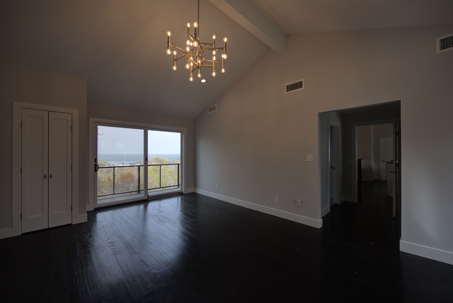 Spacious master bedroom with chandelier and water views in a custom home by Long Island Creative Contracting, Inc. in Northport, NY