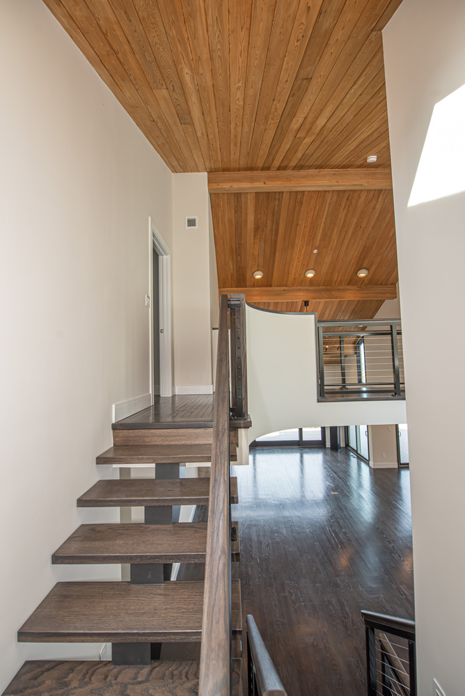 View of staircase and wood-paneled ceiling in a custom home in East Setauket by Long Island Creative Contracting, Inc