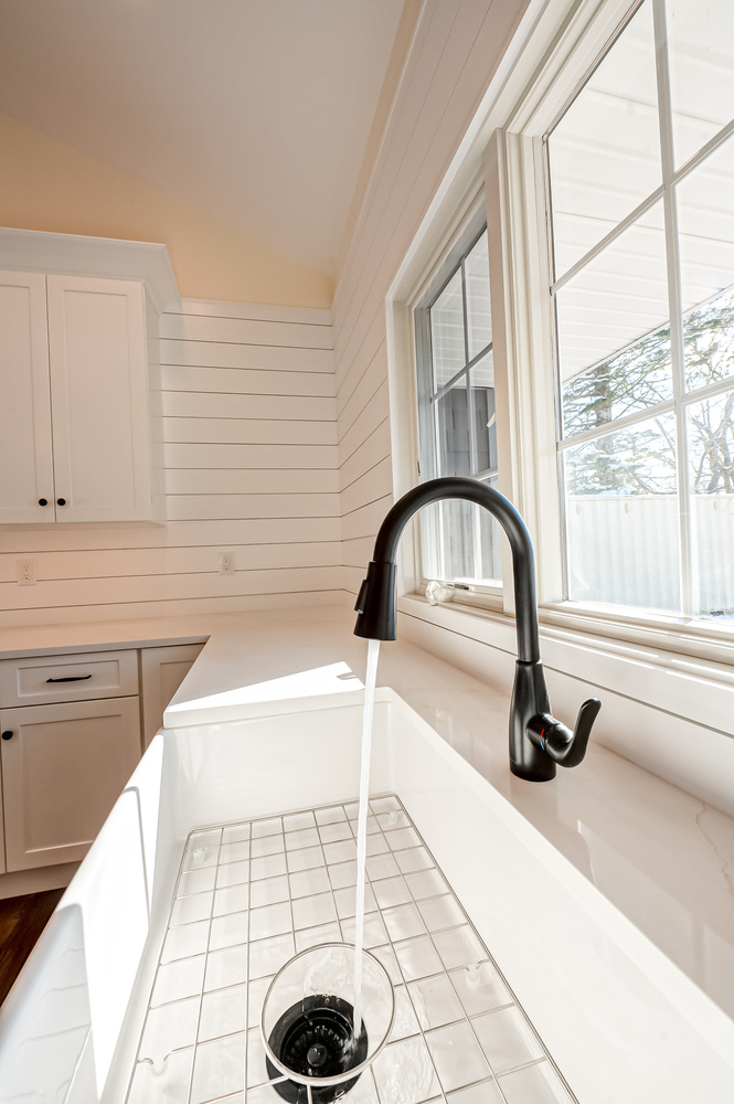 Close-up of kitchen sink and black gooseneck faucet in a Suffolk County, NY custom home remodel