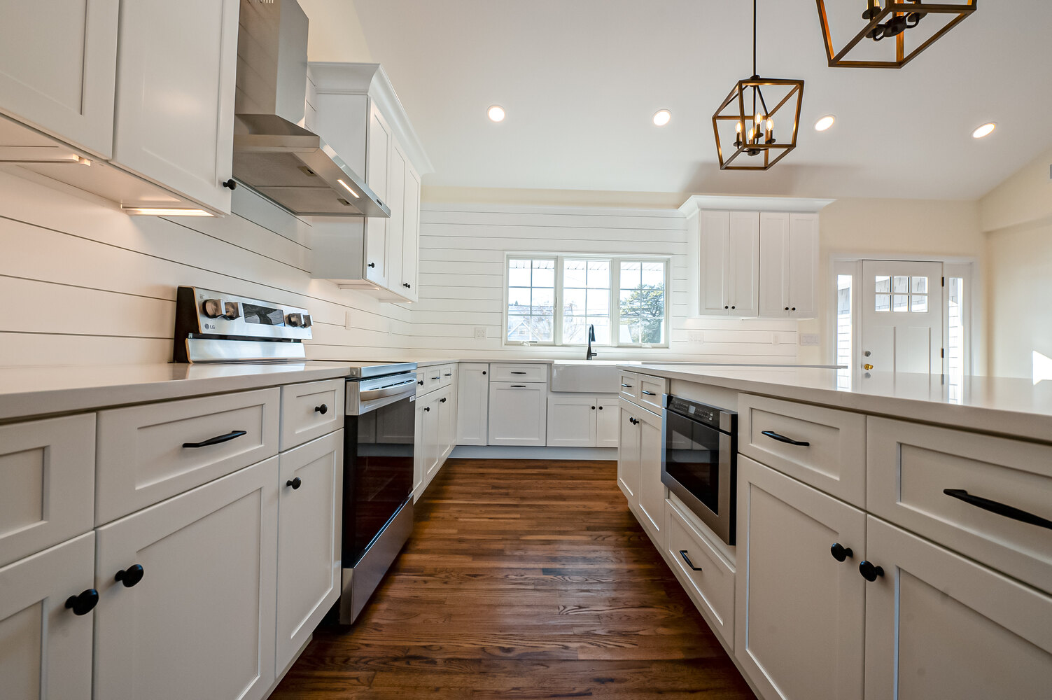 Custom kitchen design with shiplap wall and pendant lights in a Suffolk County home by Long Island Creative Contracting, Inc