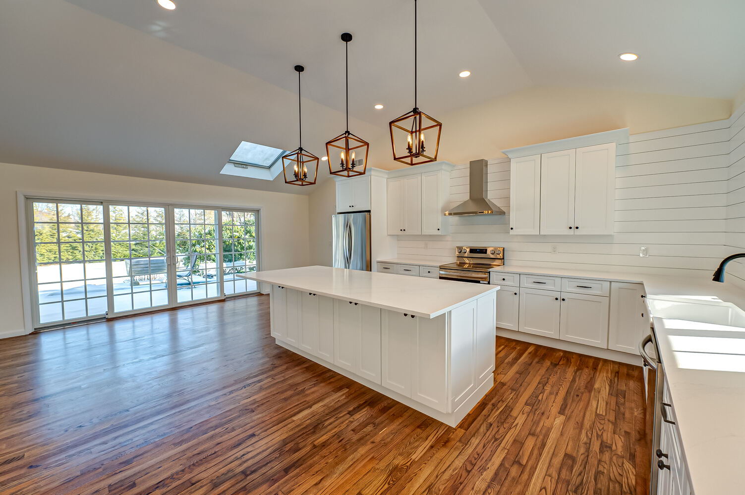Kitchen renovation with stainless appliances and white shaker cabinets in Poquott, NY by Long Island Creative Contracting