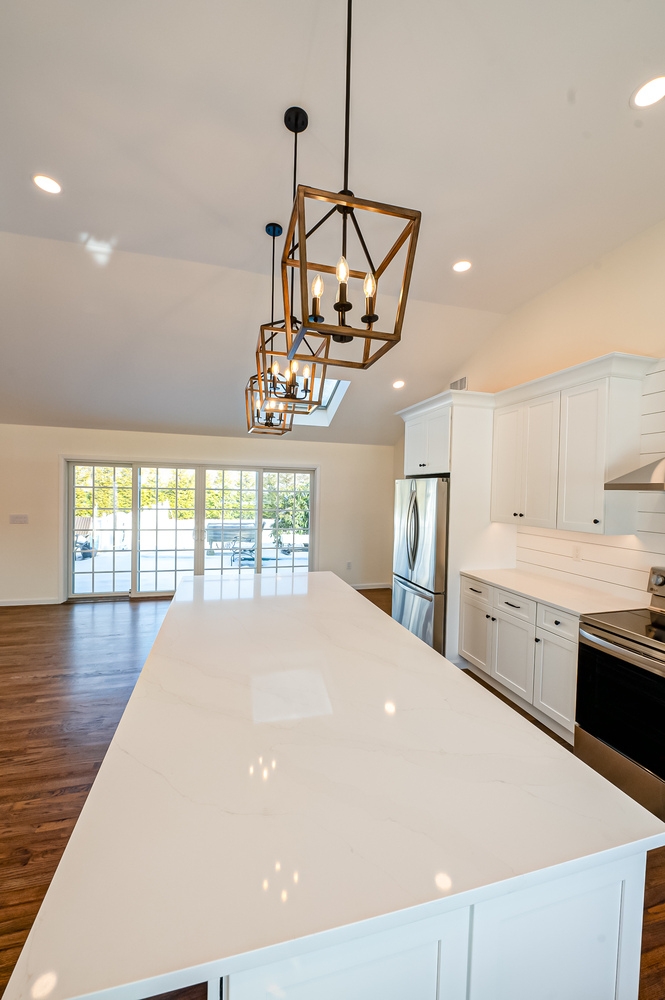 View from kitchen island to backyard through sliding doors in a Huntington, NY custom home build