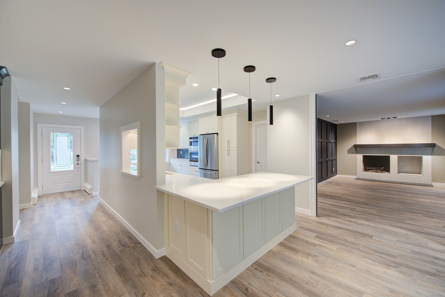 Kitchen island with pendant lighting and white cabinetry in a Suffolk County custom home by Long Island Creative Contracting, Inc