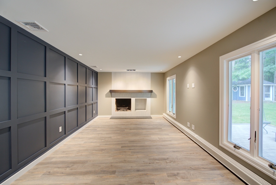 Living room with custom panel wall and modern fireplace in a Suffolk County, NY home by Long Island Creative Contracting