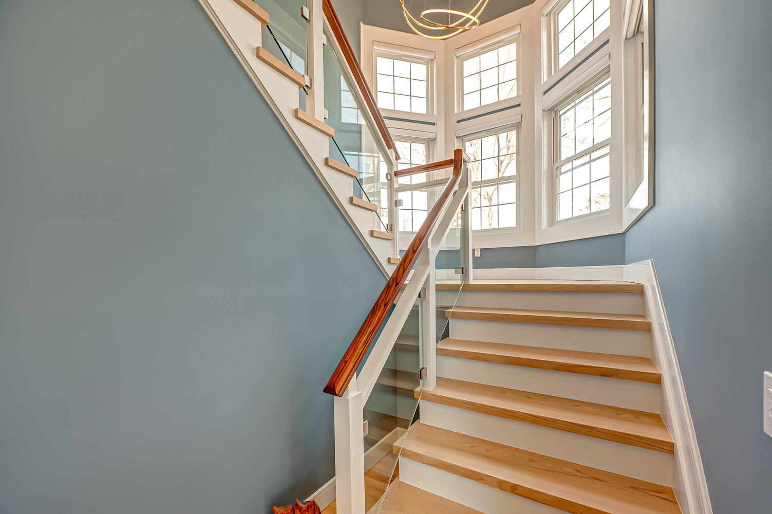 Close-up of modern staircase with hardwood treads and custom railing in Huntington, NY home