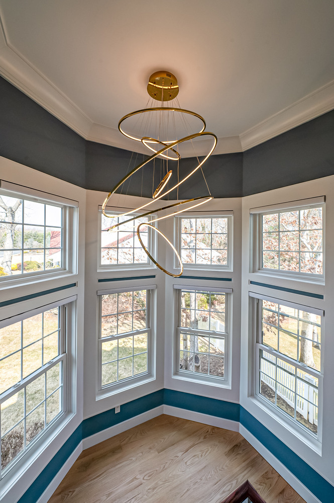 Modern chandelier suspended over custom-built bay windows in a Suffolk County, NY home by Long Island Creative Contracting, Inc