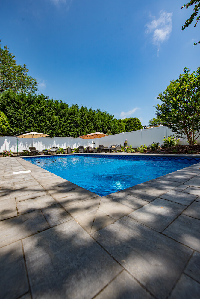 Close-up angle of custom pool and paver patio in Miller Place by Long Island Creative Contracting