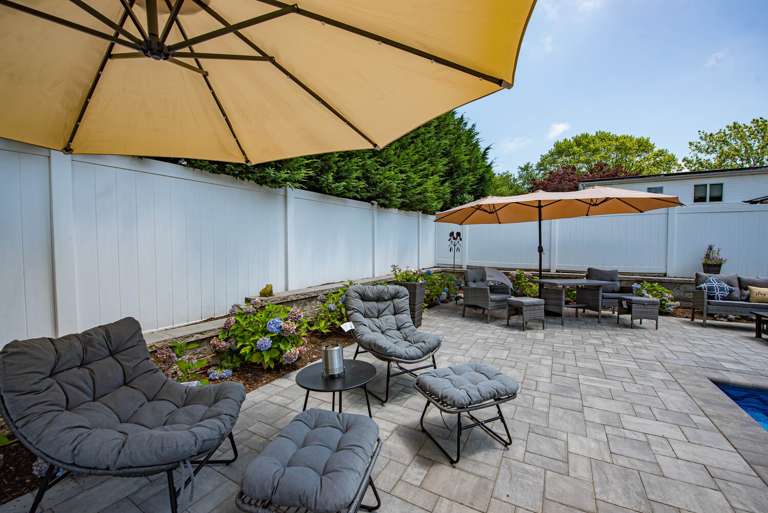 Custom patio with shaded seating area designed by Long Island Creative Contracting, Inc. in Miller Place, NY