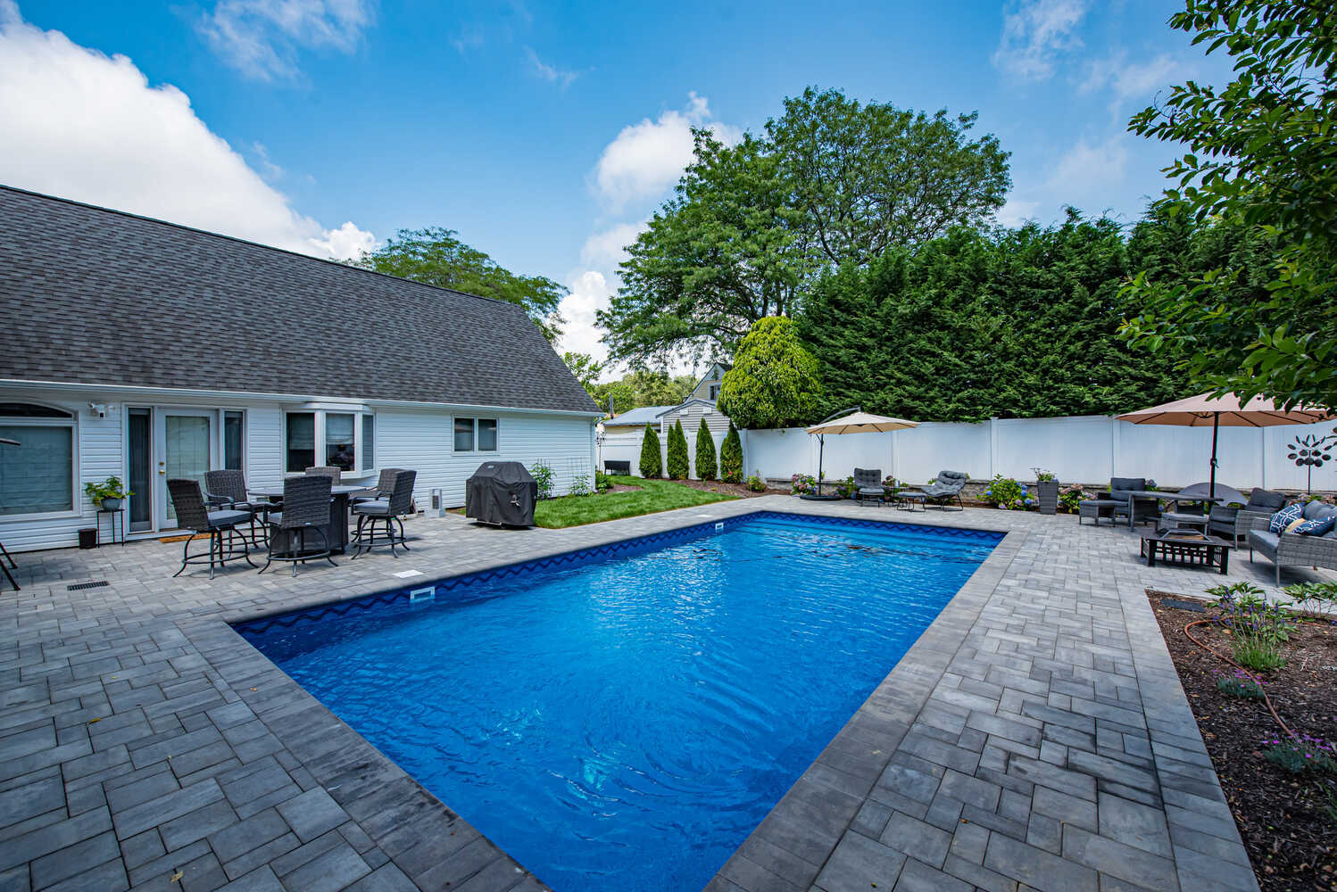 Poolside view of custom backyard design by Long Island Creative Contracting, Inc. in Miller Place, NY