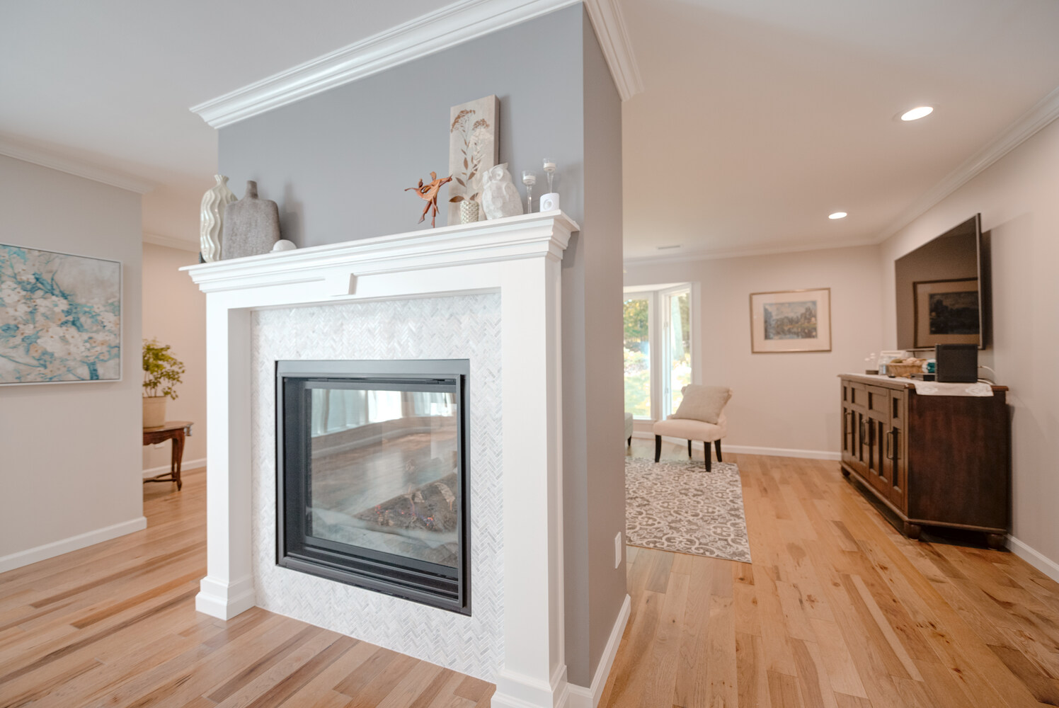 Contemporary fireplace installation dividing living and dining rooms in a Setauket, NY renovation