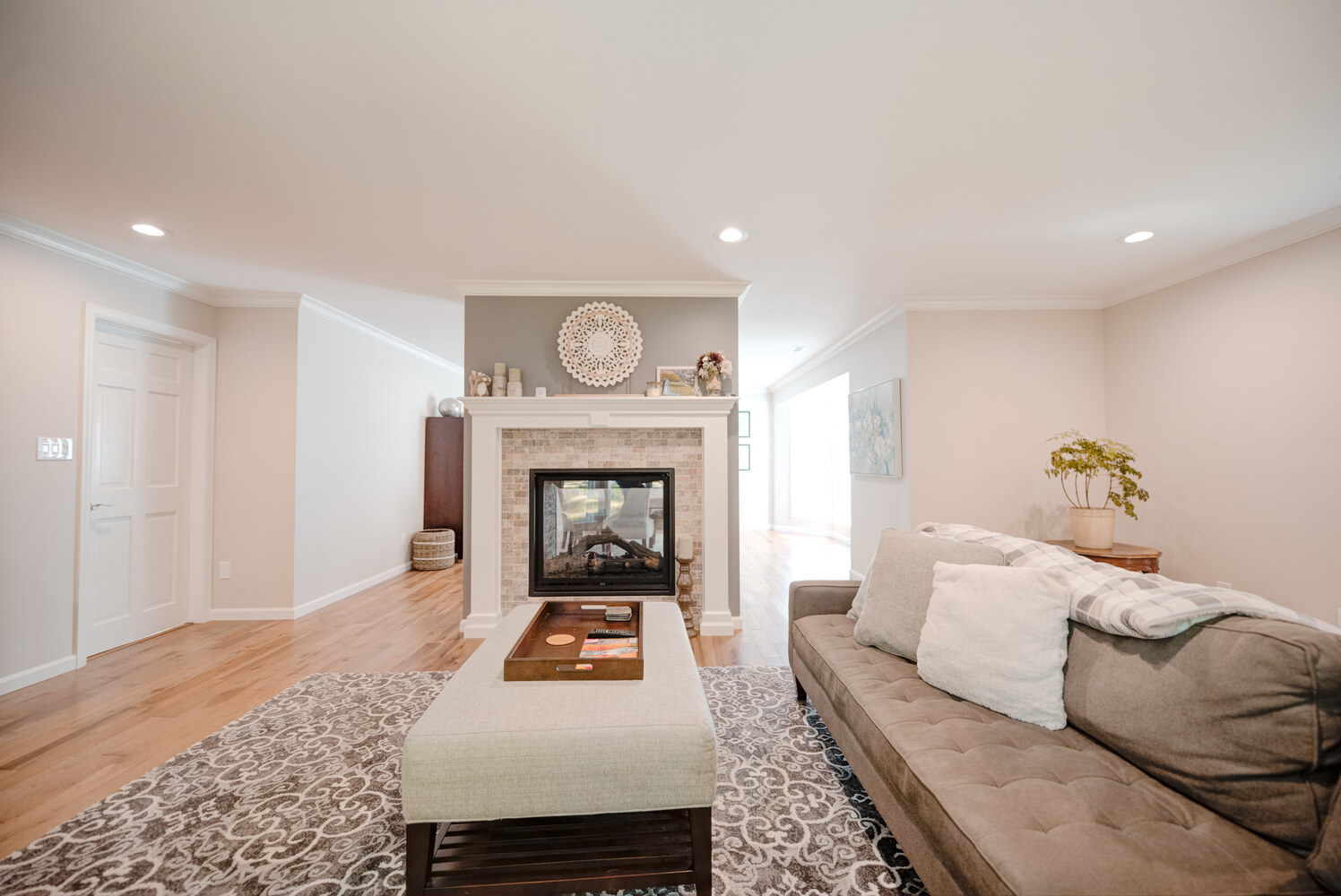 Fireplace-centered living area with neutral tones and plush furniture in Suffolk County