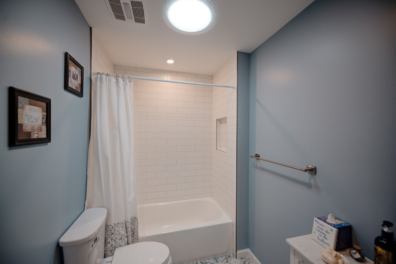Renovated bathroom with overhead lighting and custom niche in a Miller Place home by Long Island Creative Contracting