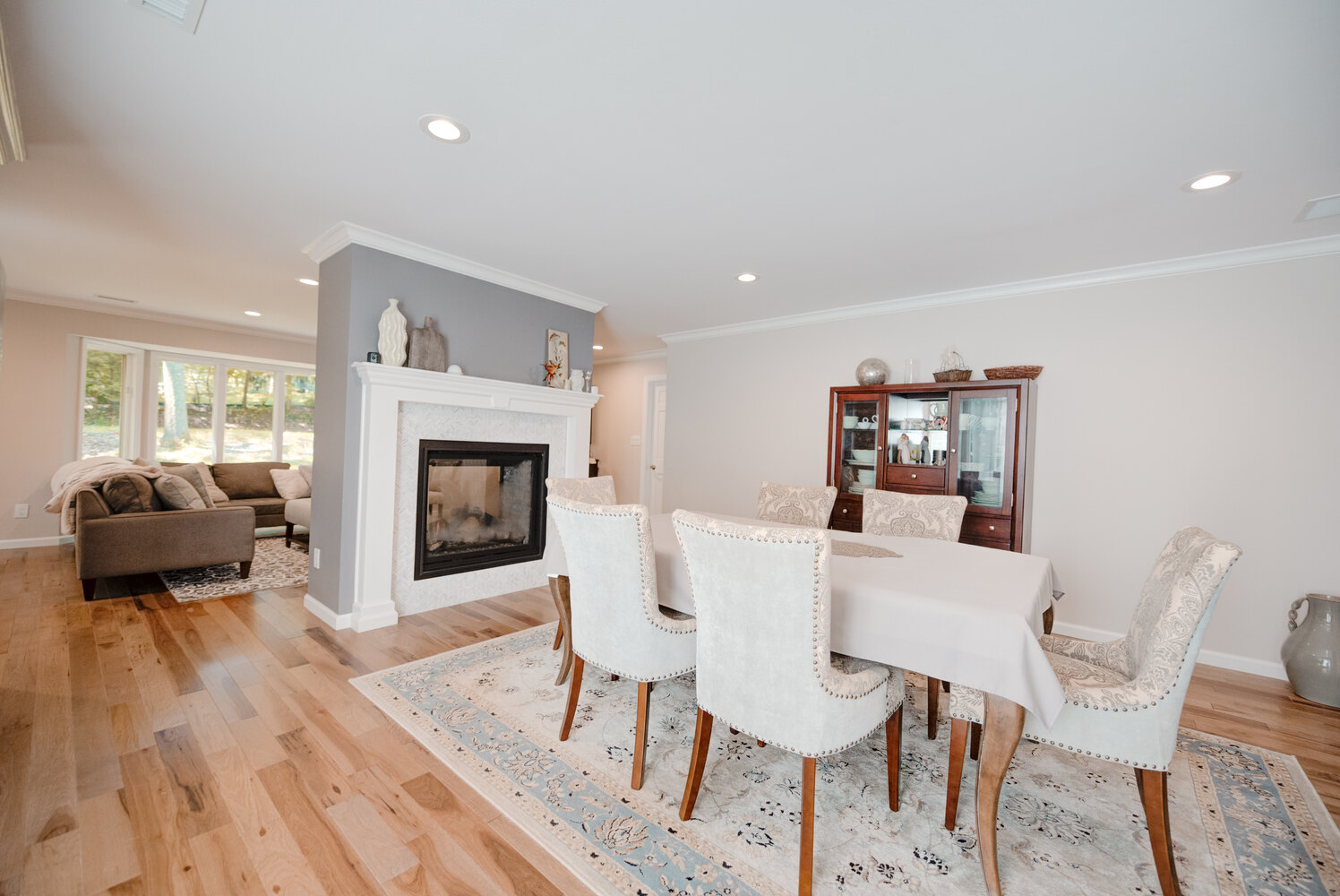 Spacious formal dining space with traditional hutch and patterned rug in Northport, NY