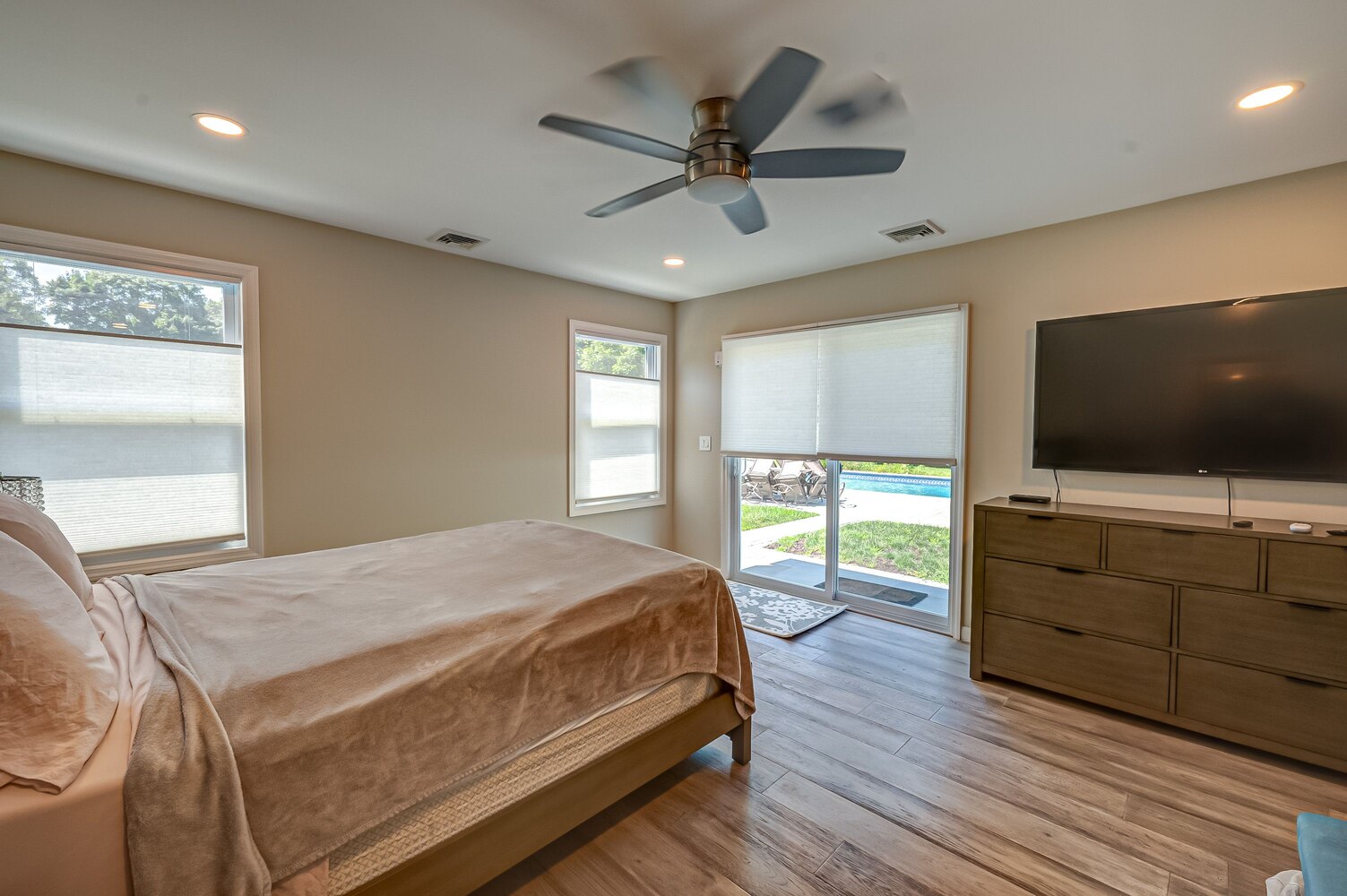 Bright bedroom with large windows and backyard access in a custom home by Long Island Creative Contracting in Huntington, NY
