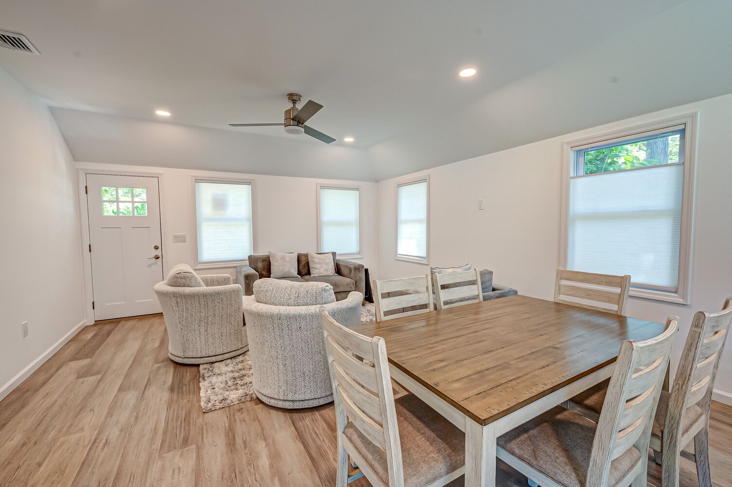 Cozy dining and living room setup with rustic wood table in a custom Suffolk County home by Long Island Creative Contracting