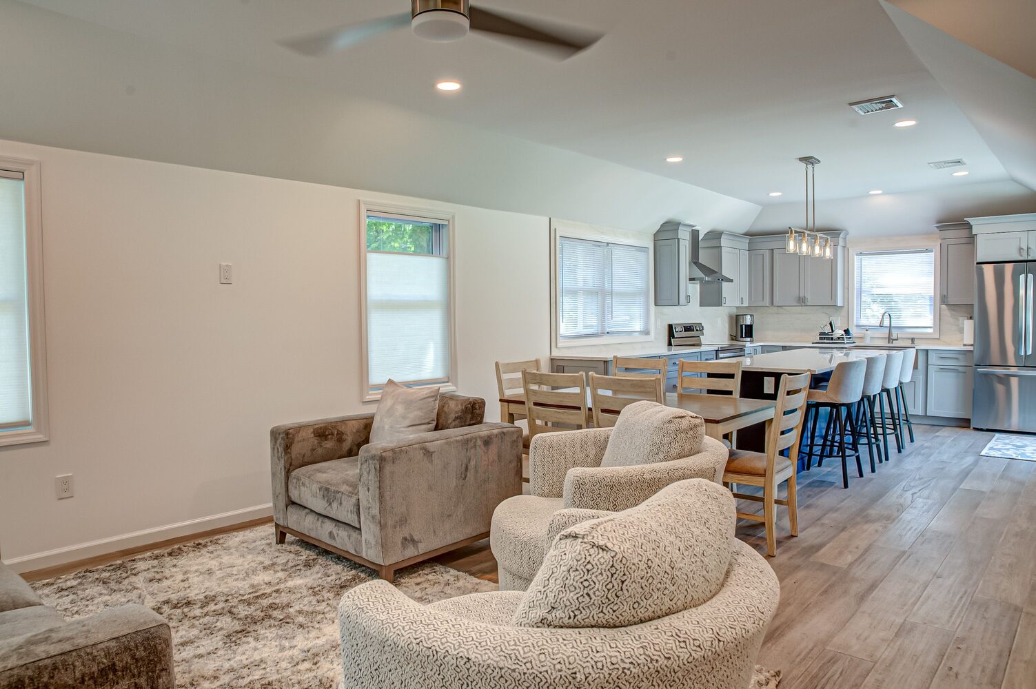 Cozy living and dining area with view into modern kitchen in a custom home by Long Island Creative Contracting in Miller Place, NY