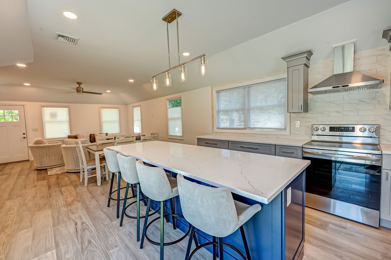Open floor plan with kitchen, dining, and living room designed by Long Island Creative Contracting in a Miller Place, NY custom home