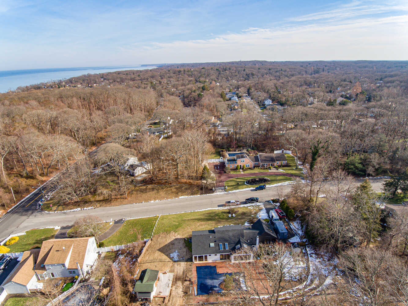 Aerial coastal view of Suffolk County neighborhood with custom home near shoreline