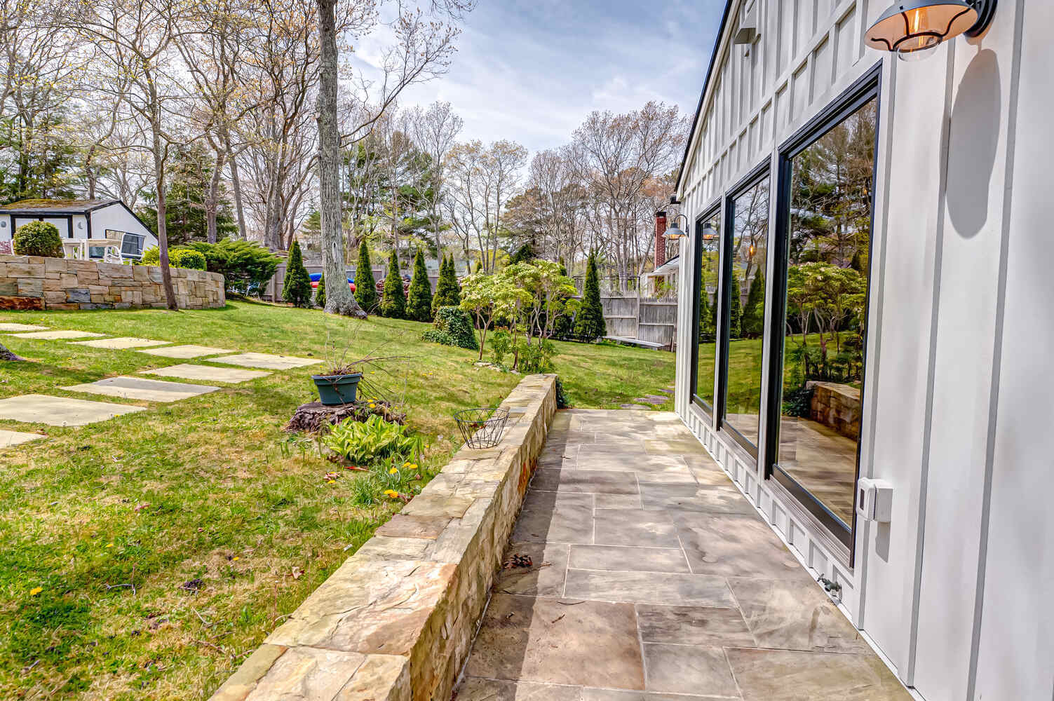 Backyard path and stone wall leading to custom home in Miller Place, NY by Long Island Creative Contracting