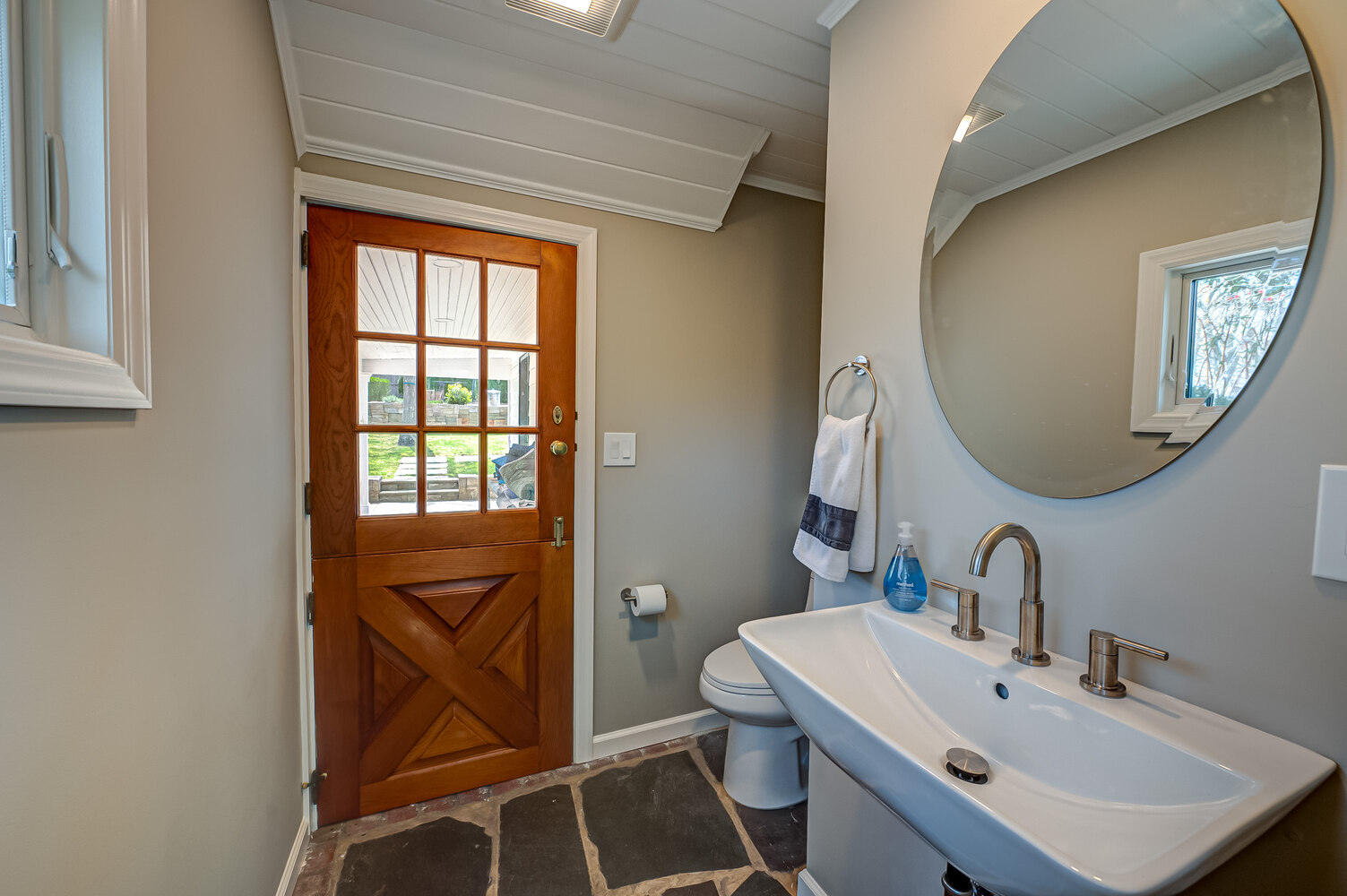 Compact powder room with a pedestal sink and wood Dutch door by Long Island Creative Contracting in Miller Place, NY