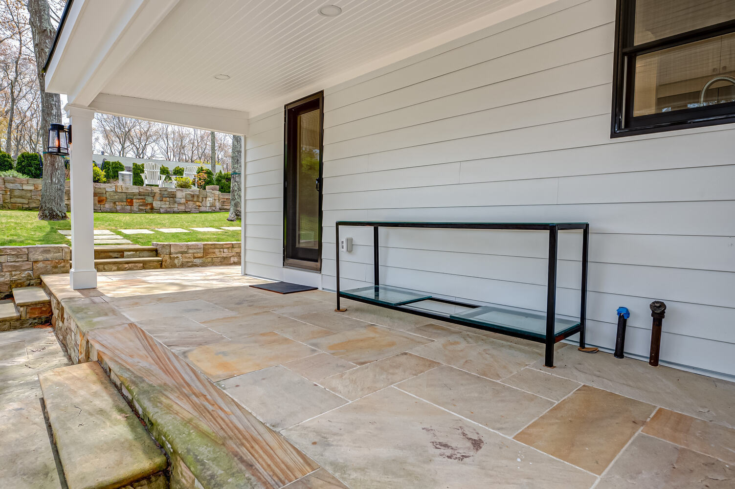 Covered porch with stone flooring on custom home by Long Island Creative Contracting in Miller Place, NY