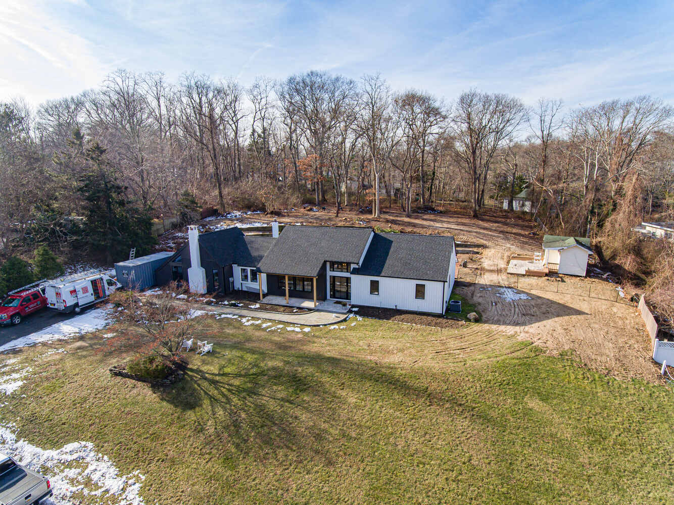 Custom home construction with contrasting rooflines and open backyard in Miller Place, NY