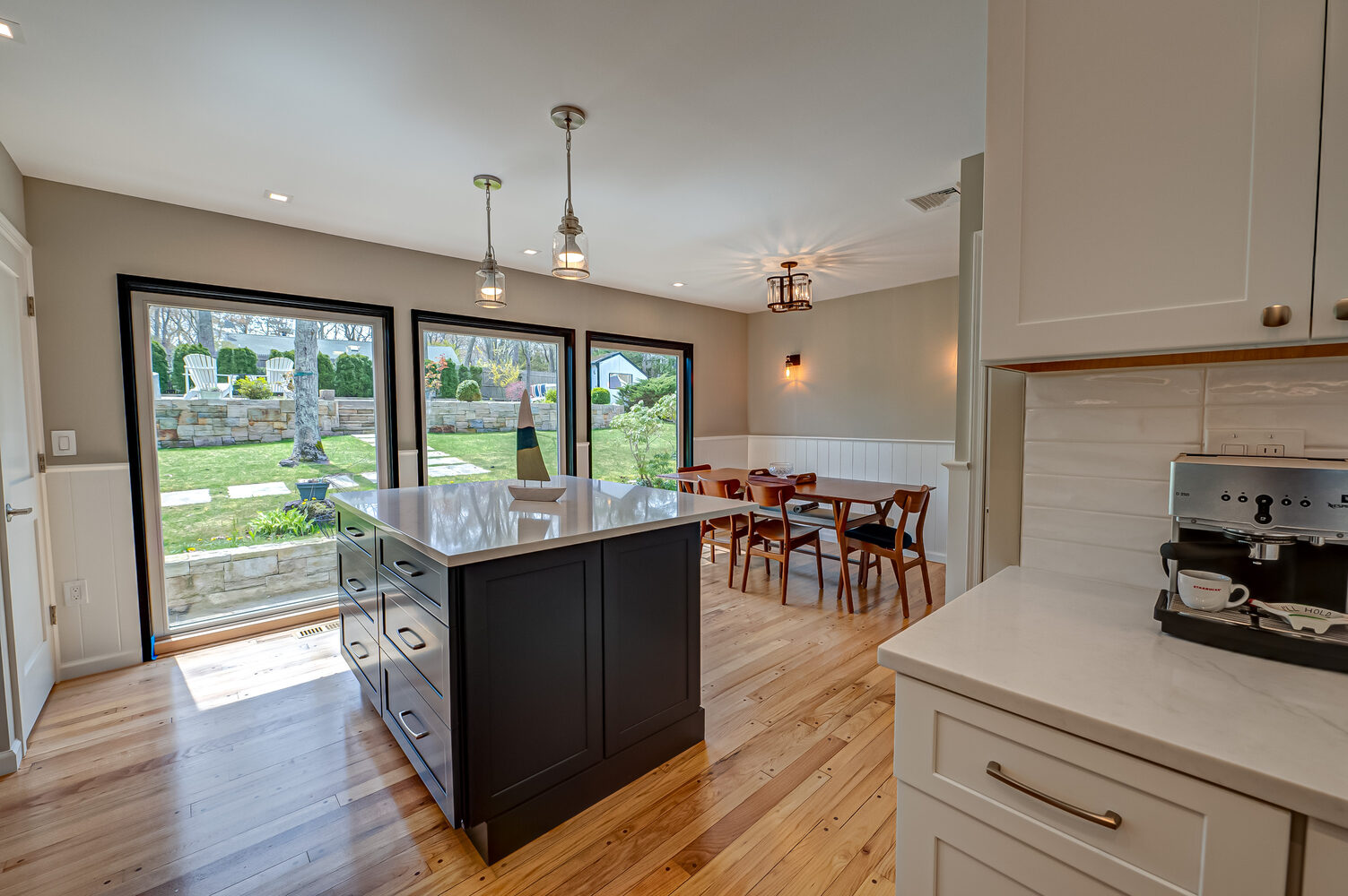 Custom home kitchen with island and full-glass views in Suffolk County, NY by Long Island Creative Contracting, Inc